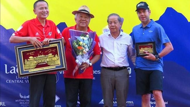 Chairman of Thua Thien - Hue provincial People's Committee Phan Ngoc Tho presents gifts to members of the organising board and racer Cadel Evans. (Photo: VNA)