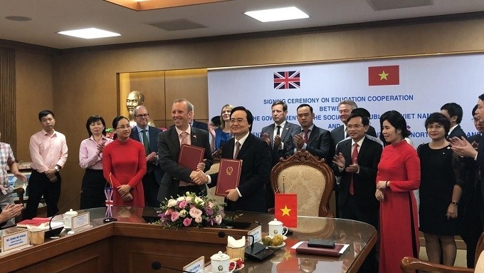 Vietnamese Minister of Education and Training Phung Xuan Nha (R) and Ed Vaizey, Trade Envoy of the UK Prime Minister, sign the MoU on educational cooperation between the two governments. (Photo: UK Embassy)