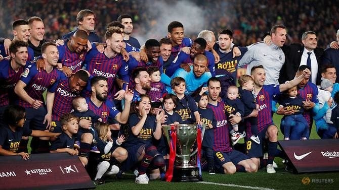 Barcelona celebrate winning the La Liga with the trophy. (Reuters)