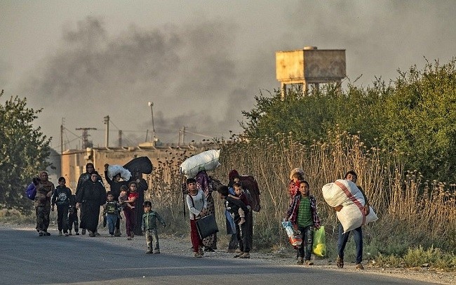 Syrian Arab and Kurdish civilians flee with their belongings amid Turkish bombardment on Syria's northeastern town of Ras al-Ain on October 9, 2019. (Photo: AFP)