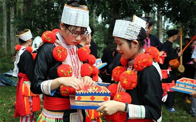 Red Dao young women dressed in their colourful and elaborately decorated traditional costumes
