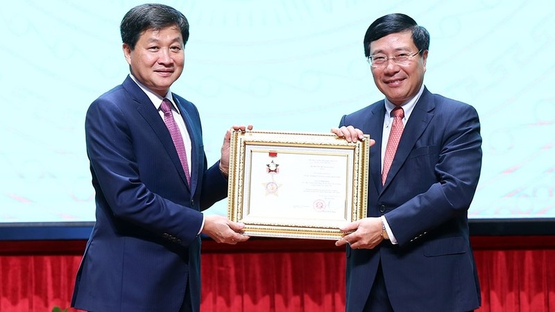 Deputy PM Pham Binh Minh presents a medal for diplomatic career to Government Inspector General Le Minh Khai. (Photo: VGP)