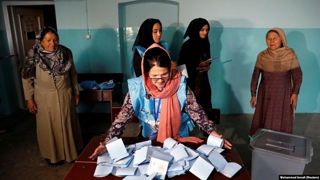 An Afghan election commission worker prepares ballot papers for counting after voting ended on September 28.(Photo: Reuters)