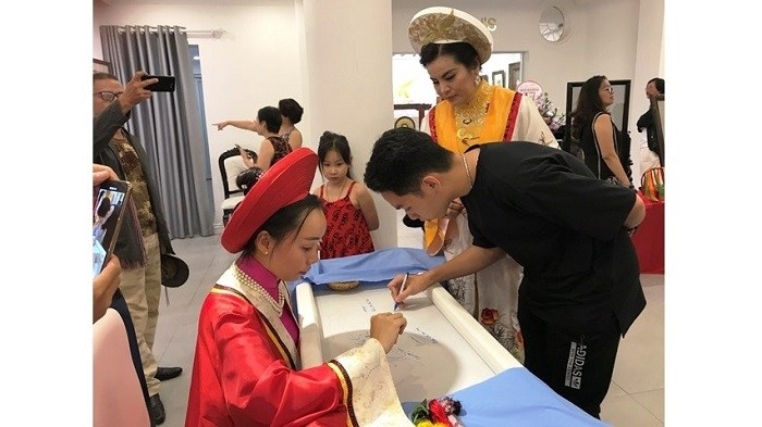 Visitors learn how to embroider. (Photo: NDO/Tien Cuong)