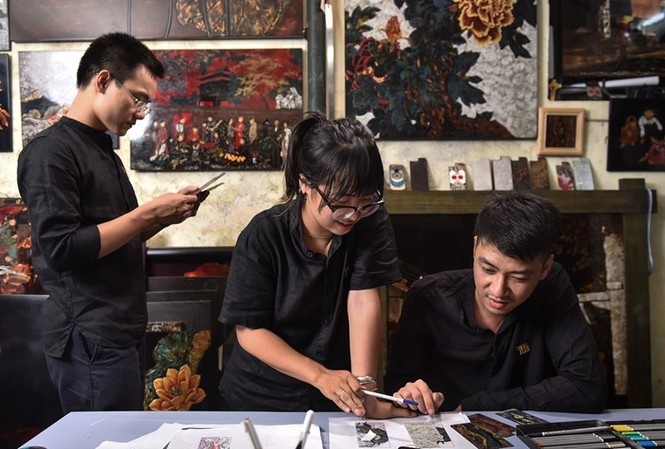 Youngsters try their hands at working with lacquer while attending a workshop hosted by La Sonmai. (Photo: tienphong.vn)