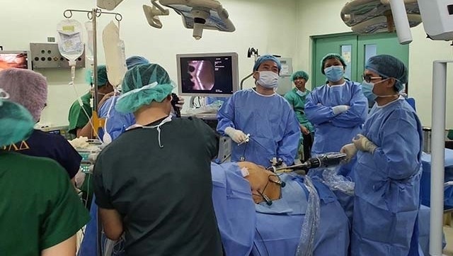 Vietnamese doctors helping their Filipino colleagues perform a robotic surgery.