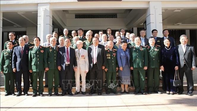 General Secretary of the Lao People’s Revolutionary Party and President of Laos Bounnhang Vorachith (centre, front row) joins a group photo with former Vietnamese voluntary soldiers and experts in Laos after hosting a reception for them in Hanoi on October 29. (Photo: VNA)
