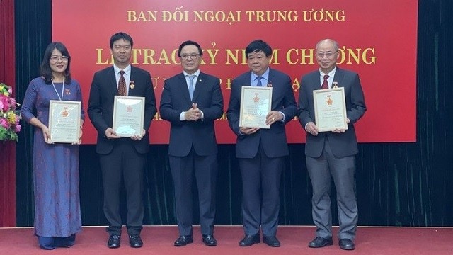 Head of the Communist Party of Vietnam Central Committee's Commission for External Affairs Hoang Binh Quan (middle) presents the “For the cause of the Party's foreign affairs” insignia to officials. (Photo: VOV)