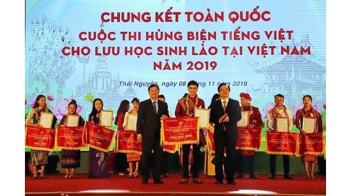 Minister of Education and Training Phung Xuan Nha (R) and President of Vietnam-Laos Friendship Association Tran Van Tuy (L) presented the special prize to winner Boun Soukhaluck (C) at the final round. (Photo: NDO/The Binh)
