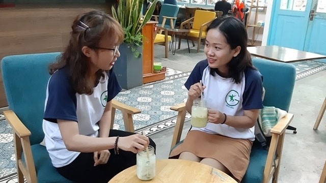 Young people using bamboo straws at a green cafe 