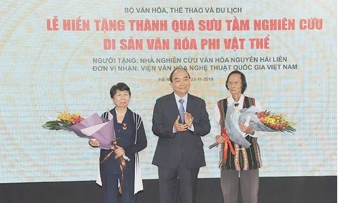 PM Nguyen Xuan Phuc presents flowers to researcher Nguyen Hai Lien (right) at the ceremony.