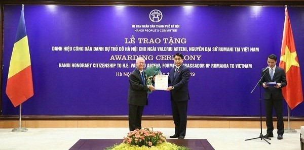 Chairman of the municipal People’s Committee Nguyen Duc Chung (R) presents the title Honorary Citizenship of Hanoi to former Romanian Ambassador to Vietnam Valeriu Arteni. (Photo: thanglong.chinhphu.vn)