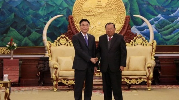Minister Le Thanh Long (L) was welcomed by General Secretary of the Lao People’s Revolutionary Party and President of Laos Bounnhang Vorachith (Photo: VNA)