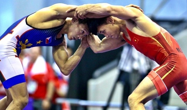 Vietnamese wrestler Nguyen Van Cong (in red) competes in the men's 57kg freestyle final.