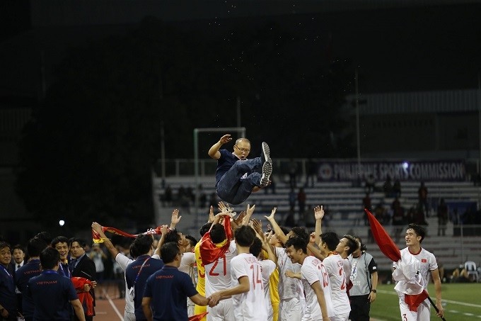 Vietnamese players celebrate their maiden SEA Games men's football title by throwing coach Park Hang-seo up in the air.