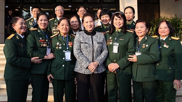 National Assembly Chairwoman Nguyen Thi Kim Ngan (C) joins a group photo with veteran soldiers of the Special Operation Force at the National Assembly House in Hanoi on December 16, 2019. (Photo: VNA)