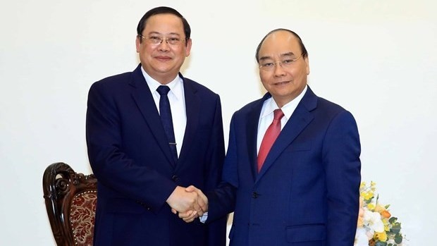 Prime Minister Nguyen Xuan Phuc (R) and Lao Deputy Prime Minister and Minister of Planning and Investment Sonsay Siphandone (Photo: VNA)