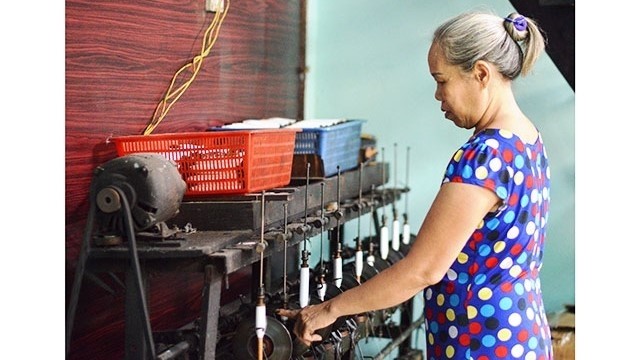 Truong Thi Hoa checks woven products. 