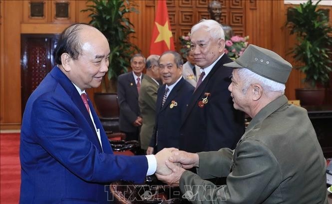 Prime Minister Nguyen Xuan Phuc and revolutionary veterans at the event (Photo: VNA)
