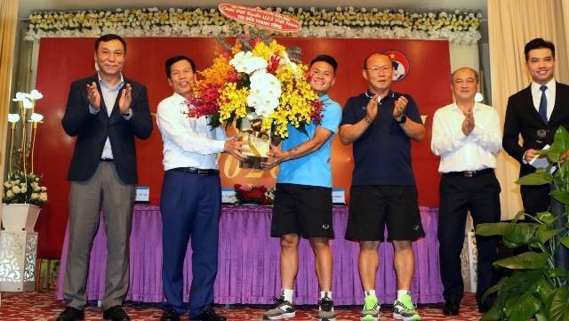 Under the authorisation of PM Nguyen Xuan Phuc, Minister of Culture, Sports and Tourism Nguyen Ngoc Thien (second from left) presents a bouquet of flowers to captain Nguyen Quang Hai, wishing Vietnam U23s a successful campaign at the 2020 AFC U23 Championship.