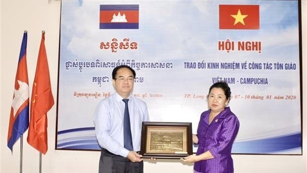 Head of the Government Committee for Religious Affairs Vu Chien Thang (left) presents a gift to Deputy Secretary of State at the Cambodian Ministry of Religions and Cults, Min Chandyneth,at the conference. (Photo: VNA)