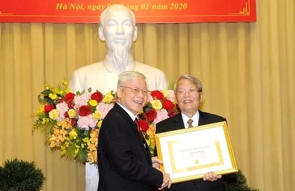 Party General Secretary and President Nguyen Phu Trong presents the 60-year Party membership insignia to former Politburo member and former President Tran Duc Luong.