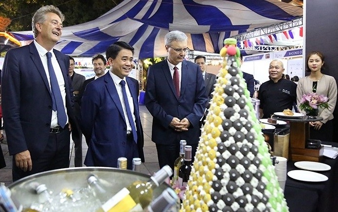 Chairman of the Hanoi People’s Committee Nguyen Duc Chung (second from left) and French Ambassador to Vietnam Nicolas Warnery (R) visit pavilions at the festival.