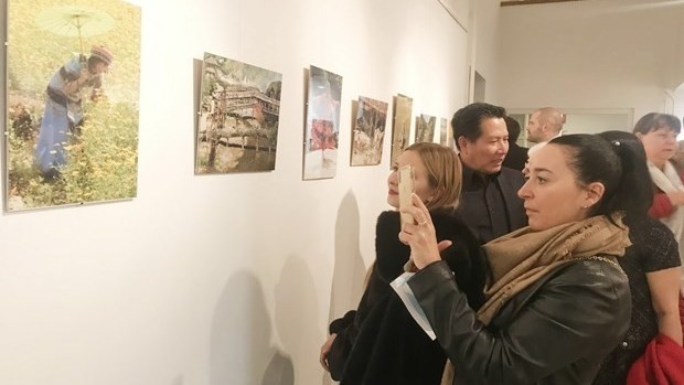 Visitors admiring photo on display at the exhibition (Photo: VNA)