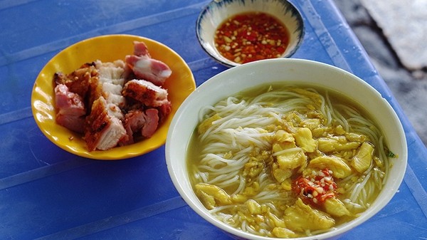A bowl of Chau Doc fish noodle soup is served along with a plate of roasted pork and a bowl of fish sauce. (Photo: VnExpress/Phong Vinh)