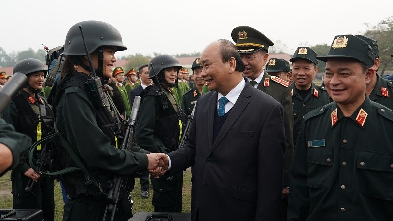 PM Nguyen Xuan Phuc shakes hand with a member of the mobile police force. (Photo: VGP)