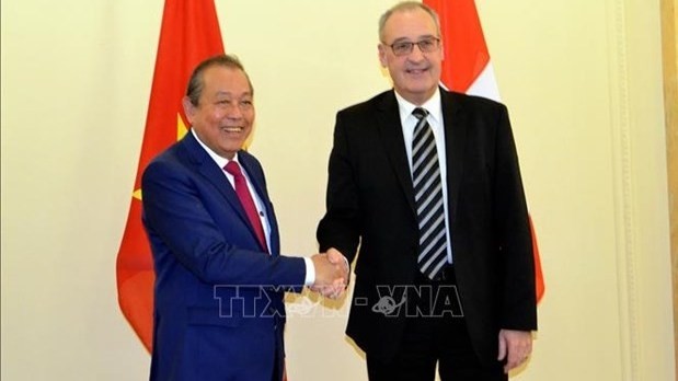 Permanent Deputy Prime Minister Truong Hoa Binh (L) and Vice President and head of the Department of Economic Affairs, Education and Research of Switzerland Guy Parmelin (Photo: VNA)