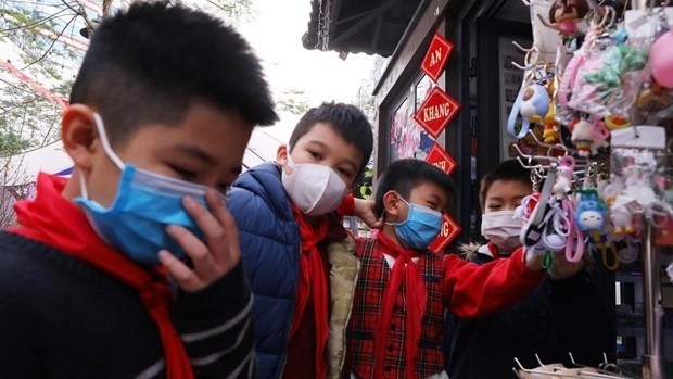 Children wear facemasks while visiting the Hanoi Book Street on January 31 (Photo: VNA)