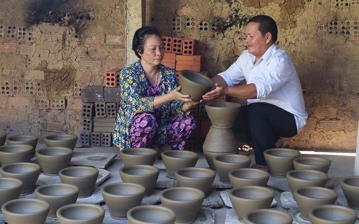 Artisan Dang Van Trinh and his wife, Pham Thi Thu Cuc, checking the quality of their pottery products (Photo: Lam Uyen)