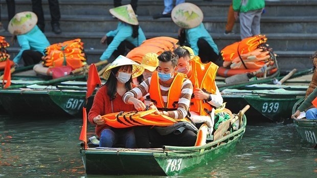 Tourists wear face masks while visiting the Trang An Landscape Complex in Ninh Binh province (Photo: VNA)