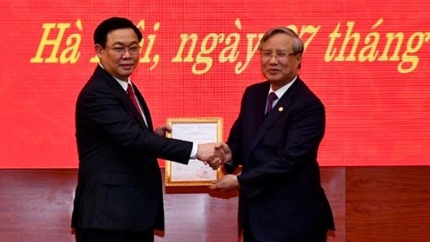 Politburo member Tran Quoc Vuong presents Politburo’s Decision No. 1818 to Politburo member Vuong Dinh Hue (L), appointing him as the secretary of the Hanoi Party Committee. (Photo: NDO/Duy Linh)