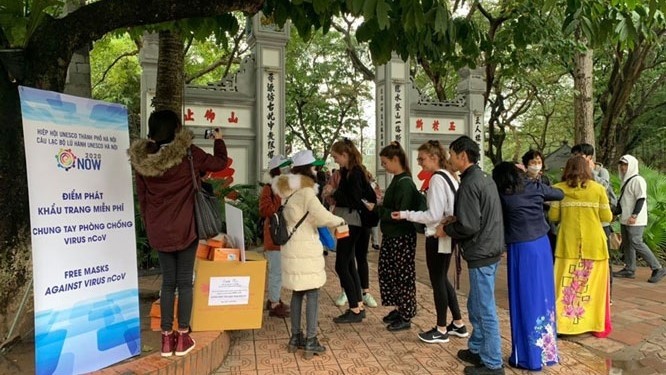 Visitors to Ngoc Son Temple are provided with free masks. (Photo: hanoimoi.com.vn)