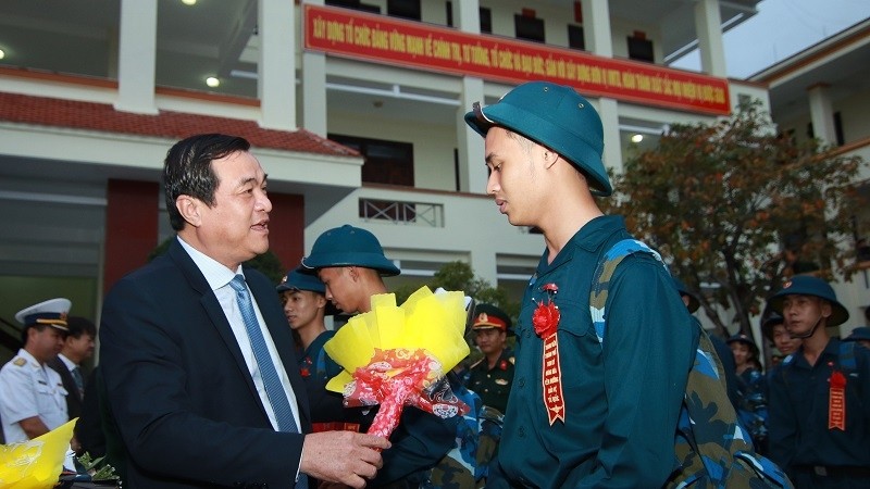 Quang Nam Party Secretary Phan Viet Cuong presents flowers to a new soldier.