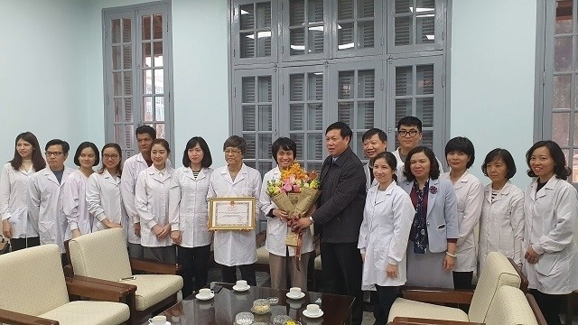 Deputy Minister of Health Do Xuan Tuyen (centre, in black) gives certificates of merit to individuals and the National Institute of Hygiene and Epidemiology for successfully cultivating and isolating the novel coronavirus. (Photo: NDO/Tran Nguyen)