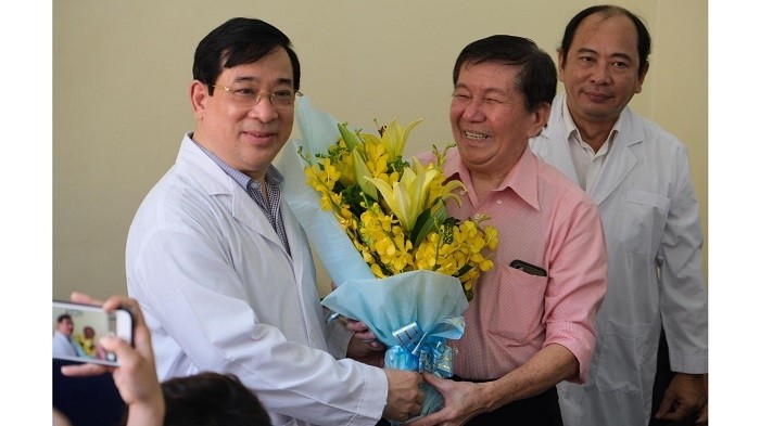 Assoc. Prof., Dr. Luong Ngoc Khue, Head of the Health Ministry's Medical Services Administration Department (far left) congratulates the Vietnamese-American Covid-19 patient on his recovery. (Photo: suckhoedoisong.vn)