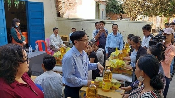 Minister at the Vietnamese Embassy in Cambodia Lai Xuan Chien presents gifts to fire victims. (Photo: NDO)