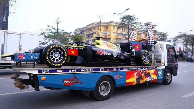 The F1 model car is carried on a truck during the parade in Hanoi on February 22. (Photo: Zing.vn)