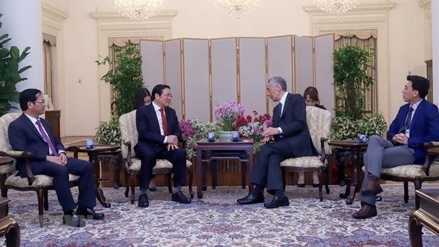 Secretary of the CPV Central Committee and head of the Party Central Committee’s Commission for Internal Affairs Phan Dinh Trac (second from left) meets with Singaporean PM Lee Hsien Loong (Photo: VNA)