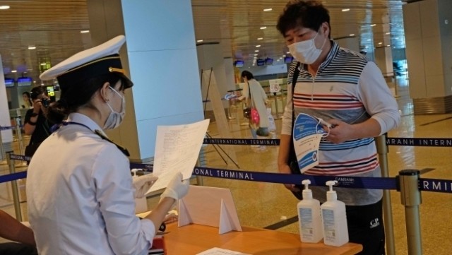A quarantine staff member inspects the medical declaration of a passenger on a flight from the Republic of Korea to Cam Ranh Airport in Khanh Hoa Province on the afternoon of February 25, 2020. (Photo: VNA)