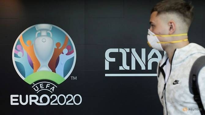 FILE PHOTO: Travellers pass by a logo of the 2020 UEFA European Football Championship displayed on a wall inside Bucharest Henri Coanda International Airport, in Otopeni, Romania, March 16, 2020. (Reuters)