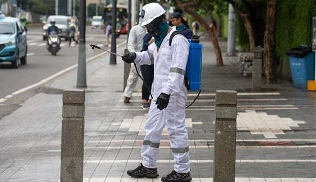 The medical staff spraying disinfectants at the public areas in Indonesian capital city of Jakarta on March 19. (Photo: xinhua/VNA)