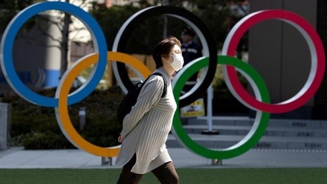 A woman wearing a protective face mask, following an outbreak of the coronavirus disease (COVID-19), walks past the Olympic rings in front of the Japan Olympics Museum in Tokyo, Japan March 13, 2020. (Photo: Reuters)