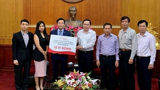 VFF President Tran Thanh Man (C) receives VND10 billion donated by Toyota Vietnam to support the COVID-19 fight, Hanoi, March 24, 2020. (Photo: NDO/Trang Ly)