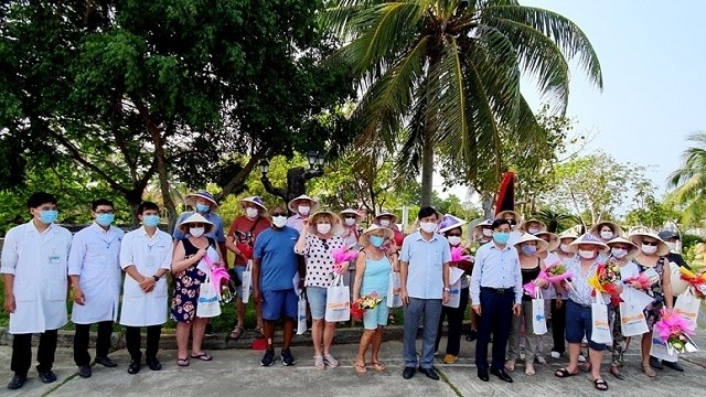 Foreign tourists pose for a group photo with Vietnamese medical staff after completing their 14-day medical isolation in Thua Thien – Hue province (Photo: baothuathienhue.vn)