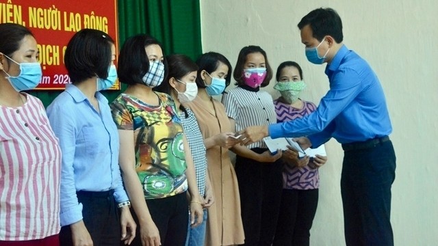 A representative from Da Nang City’s Labour Confederation presents gifts to its labour union members and employees who have lost their jobs due to COVID-19 in Hai Chau District, March 20, 2020. (Photo: NDO/Thanh Tam)