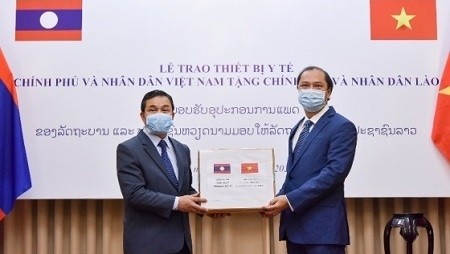 Deputy Foreign Minister Nguyen Quoc Dung (R) presents the gift to Lao Ambassador to Vietnam Sengphet Houngboungnuang (Photo: MOFA) 